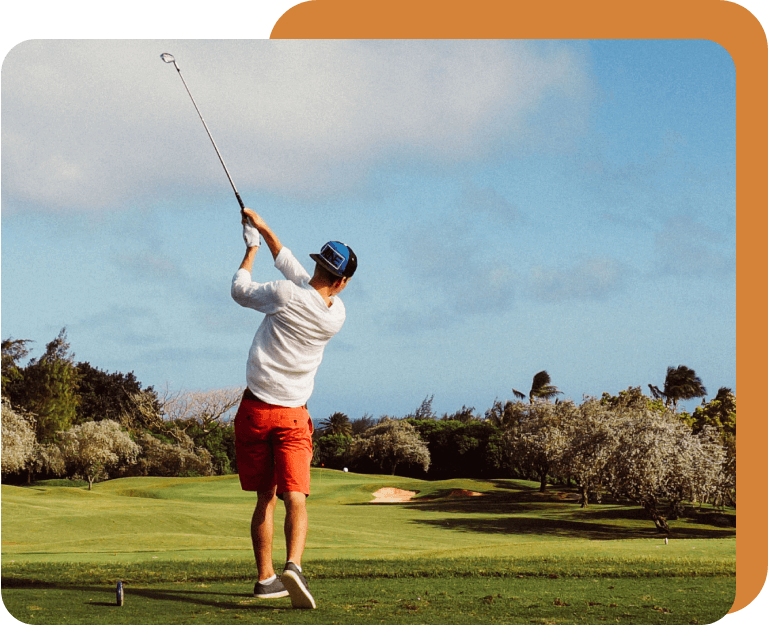 A man swinging at the golf ball on a course.